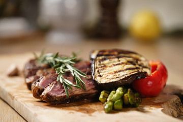 sliced medium rib eye steak with grilled vegetables