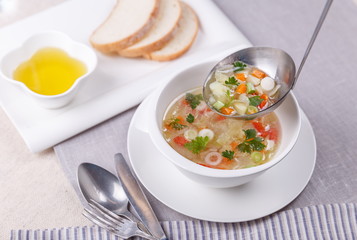 Fresh vegetable soup made of cabbage, carrot, potato, red bell pepper, tomato in bowl