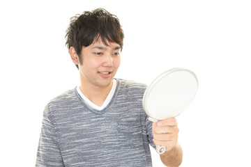 手鏡を持ち微笑む男性