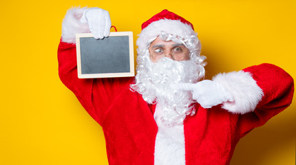 Fototapeta na wymiar Funny Santa Claus holding black board