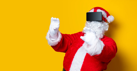 Fototapeta na wymiar Funny Santa Claus have a joy with VR glasses