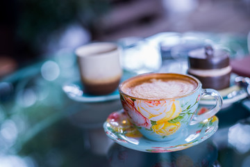 Cup of hot drink with coffee on table.