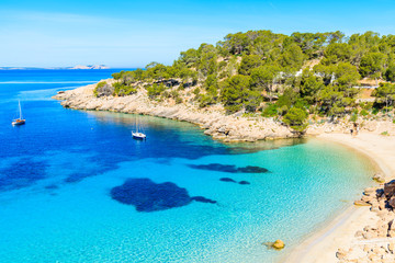 View of beautiful beach in Cala Salada famous for its azure crystal clear sea water, Ibiza island, Spain - obrazy, fototapety, plakaty