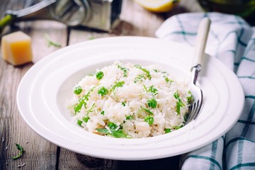 Homemade risotto with chicken, green peas, arugula and parmesan