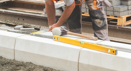 Construction worker working hard leveling concrete pavement outdoors.