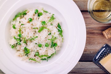 Homemade risotto with chicken, green peas, arugula and parmesan