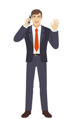  Businessman talking on the mobile phone and greeting someone with his hand raised up