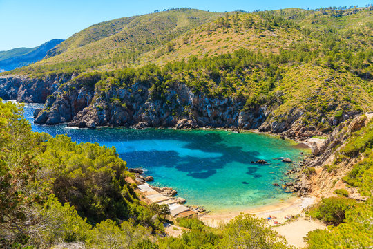 View of secluded Cala d'en Serra beach and coastal cliff rocks, Ibiza island, Spain