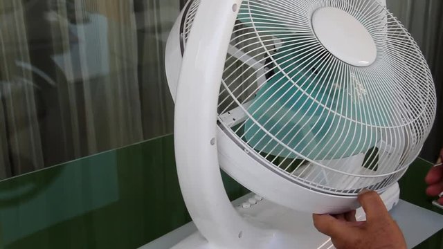 Male Hands Collecting a Home Fan Ventilator on the Table