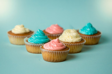 Freshly baked colorful cupcakes on blue background