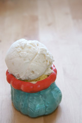 delicious vanilla ice cream in green with red ceramic glass cup vintage style and soft focus on the wood table for dessert at home or cafe and restaurant with space