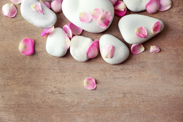 Spa stones and petals on textured background