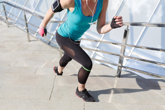 Full length shot of healthy young woman climbing up and running on stairs