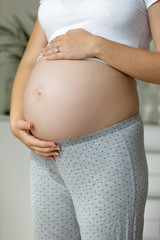 Closeup photo of young pregnant woman on the 9 month of pregnancy