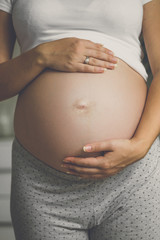 Toned closeup photo of young pregnant woman on the 9 month