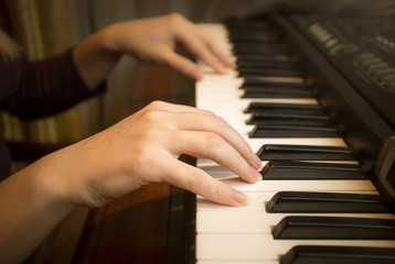 Fototapeta na wymiar Closeup image of female hands playing on piano