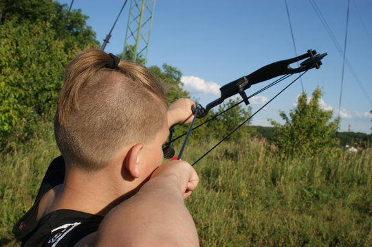 Bow and arrows, hunting by the river, young blue-eyed hunter.