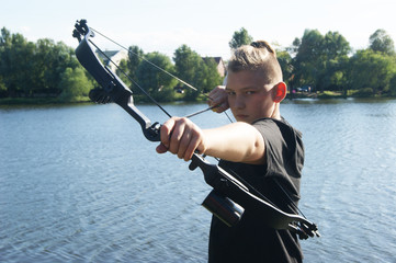 Bow and arrows, hunting by the river, young blue-eyed hunter.