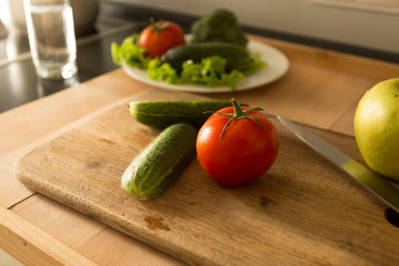 Toned photo from top of vegetables and fruits lying on wooden board at kitchen