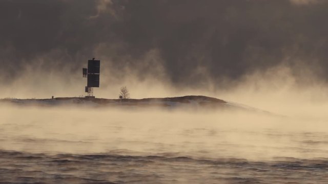 Mysterius rock with seamark surrounded by sea smoke