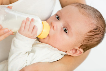 Mother feeding her 3 months old baby from bottle