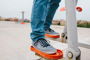 A man trains on sporting equipment in a city in the open air. The concept of a healthy lifestyle and accessibility of sports training for every person. Available sports equipment in a public place.