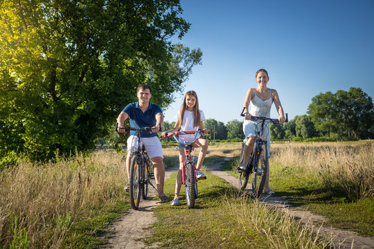 Happy family with daughter having weekend on their bicycles