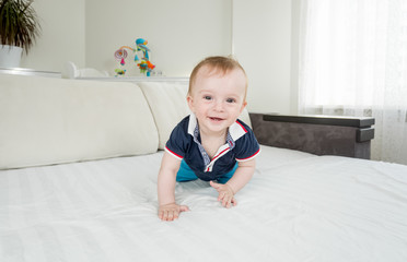 1 year old baby boy crawling on bed