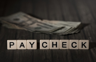 Pay Check Spelled Out in Tiles
