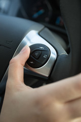 Obraz premium Closeup of driver using control panel on steering wheel