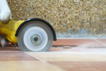 worker use grinder diamond saw cutting floor tile for home repair.