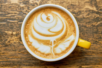 Rose latte art, top view. Cup of coffee with foam.
