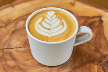 Close up of latte cup. Coffee beverage with foam art.