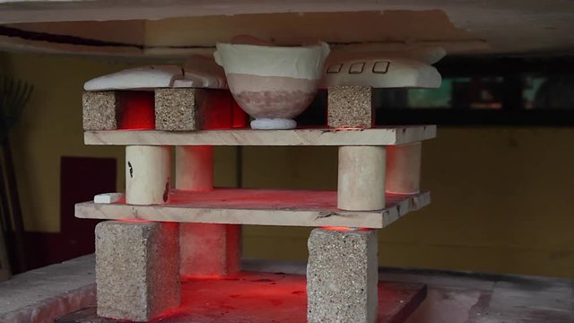 Campana de horno de ceramica de gas cerrandose con piezas de ceramica en el interior
