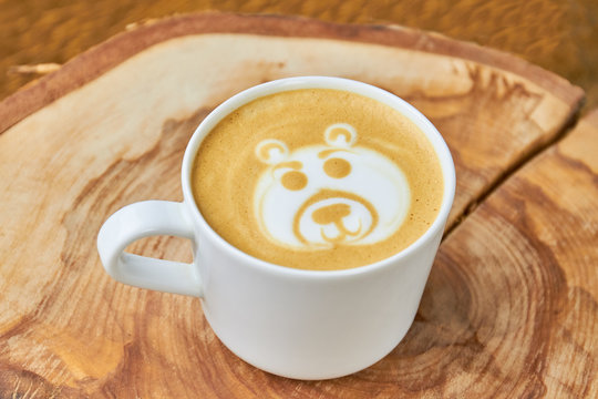 Bear coffee foam art. White cup with latte.