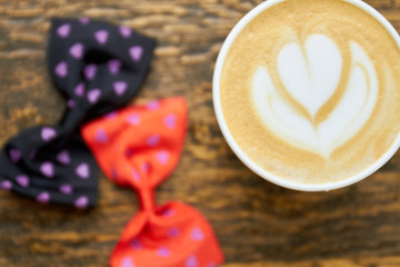 Flower latte art, close up. Coffee and bow ties.