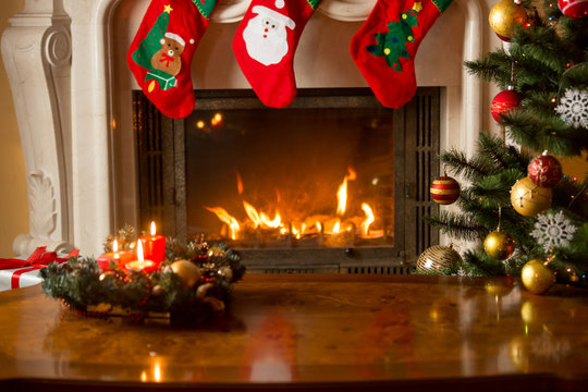 Baubles On Christmas Tree In Front Of Burning Fireplace. Beautiful Christmas Background