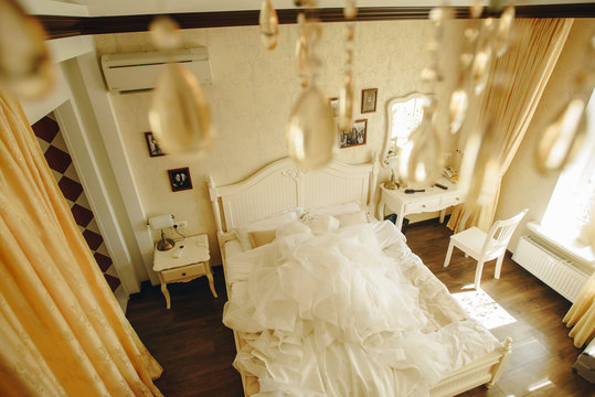 Elegancy shampane colored wedding dress on bed in style bedroom