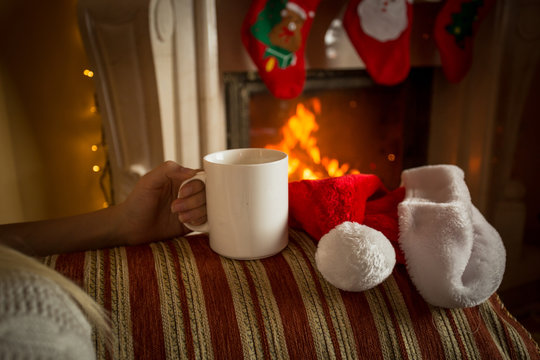Closeup image of cup of tea on sofa at fireplace