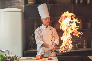  Mature man professional chef cooking meal indoors