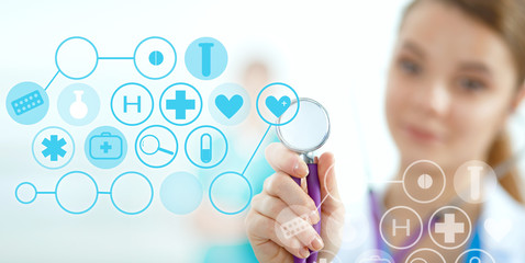 Woman doctor holding medical stethoscope and working with modern medical icons