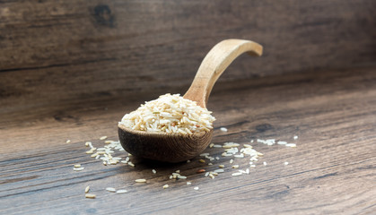  Rice in a wooden spoon on a wooden table