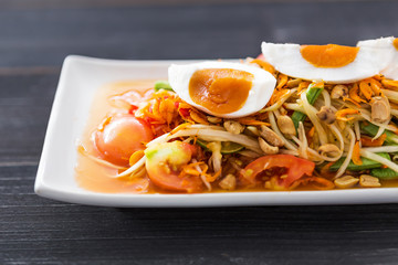 Papaya salad with salted egg, wood background, Thai food, Thai Salad tray, 