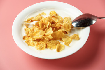 Corn flakes and yogurt in white bowl  place on pink background