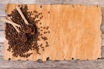 Coffee beans and wooden spoons on an old sheet of paper