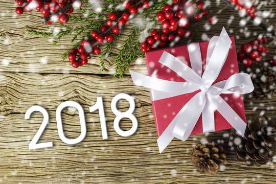 Christmas and New Year 2108 of red gift box and red winterberry on old wood