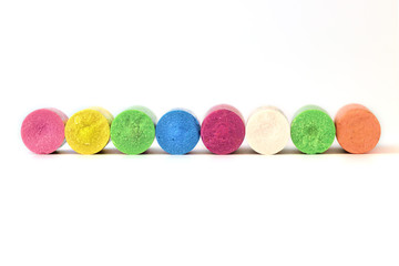 A collection of eight broken colourful crayons on white background