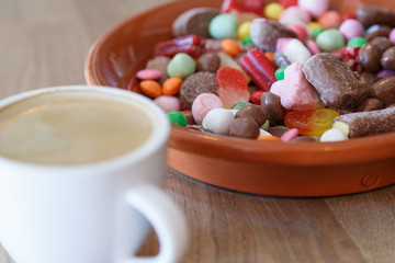 Cup of hot coffee and candies