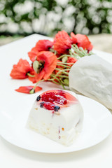 Tasty fruit pie and bouquet of poppy flowers on white table