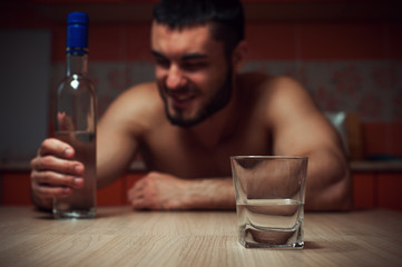 Angry depressed alcoholic man sitting at home